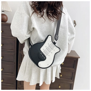 Detail of creative guitar-shaped crossbody bag with rivet accents and wide strap on model