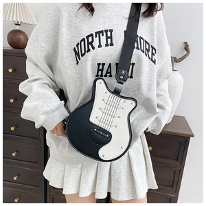 Detail view of the unique guitar shaped crossbody bag with black and white color contrast
