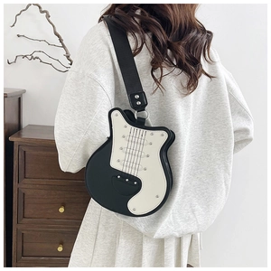 Borsa a tracolla creativa a forma di chitarra in bianco e nero indossata da una modella