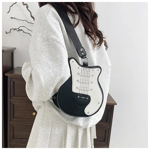 Dettaglio borsa a tracolla a forma di chitarra con design bianco e nero e borchie argento