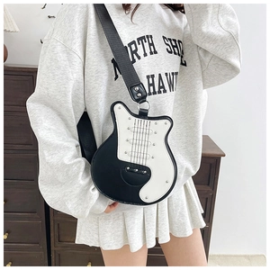 Detail view of a creative guitar-shaped crossbody bag featuring black and white faux leather