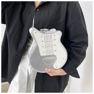 Detailed close-up of guitar-shaped silver handbag featuring metallic studs and shiny finish