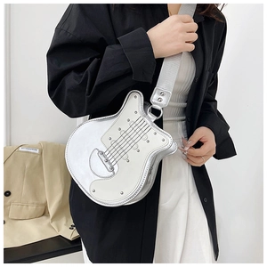 Close-up of a silver guitar-shaped crossbody bag featuring metal studs and a wide strap