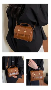 Close-up of vintage brown oil wax leather handbag with golden magnetic buckles