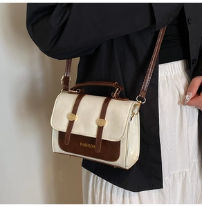 Detail of vintage cream and brown crossbody bag with gold fashion lettering buckle