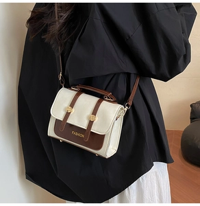 Detail of vintage square crossbody bag with contrast panel and gold buckle