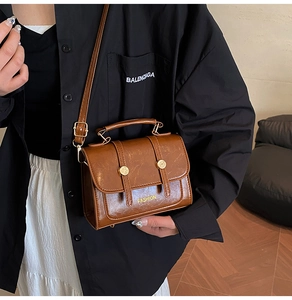 Brown vintage leather crossbody bag with FASHION lettering and golden button accents