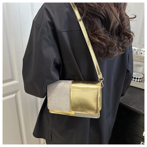 Detail view of a luxury gold and silver patchwork chain bag on a black outfit