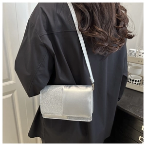 Detail of silver metallic crossbody bag with sparkling glitter panels and slim strap