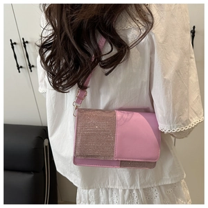 Pink crossbody bag with glitter rhinestone cover shown on model for size perspective