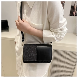 Detail of a black sequin patchwork crossbody bag with elegant gold metal hardware buckle