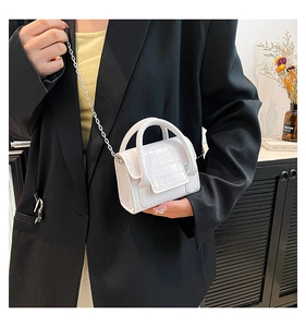 Detailed view of white mini crossbody bag featuring faux crocodile texture and silver chain