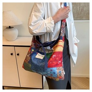 Detail of bohemian patchwork tote bag with colorful deer pattern and top drawstring closure