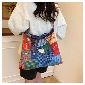 Detail of multi-color patchwork tote bag featuring artistic patterns and bow decoration