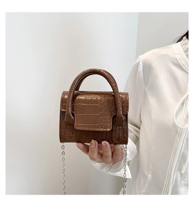 Close-up of mini dark brown stone pattern handbag with metallic chain and round handles