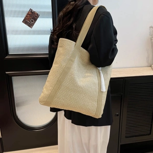 Minimalist large woven tote bag with white tassel and wide shoulder strap for summer beach