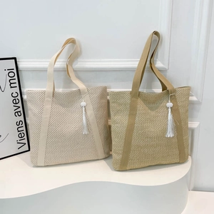 Handwoven straw tote bags in beige and khaki with decorative tassels and fabric straps