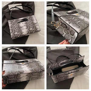 Detailansicht der Clutch mit Tiermuster, goldenen Beschlägen und Innenfächern