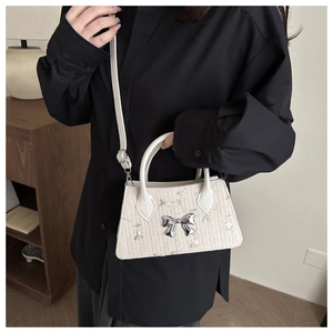 Detailed embroidery of light green flowers and silver bow on beige straw tote bag