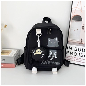 Dettaglio dello zaino nero con gatto cartoon e portamonete a pesce in tessuto di nylon