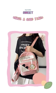 Detail of cute cat-ear backpack with heart pattern and paw charm on cross-body strap