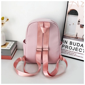 Zaino rosa a cartone animato con spallacci regolabili e tasche laterali su tavolo bianco