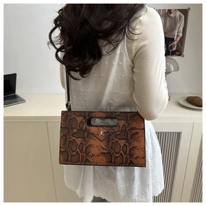 Detail of snake print crossbody bag with metallic logo and detachable shoulder strap