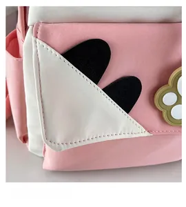 Detail of pink and white canvas backpack with cute cat ear pocket and paw print decor