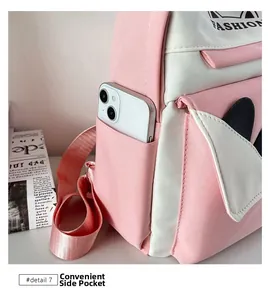 Detail of pink and white backpack showing portable side pocket with a phone inside