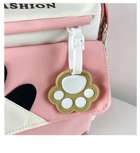 Detail of pink and white student backpack with a cute silicone cat paw zipper charm