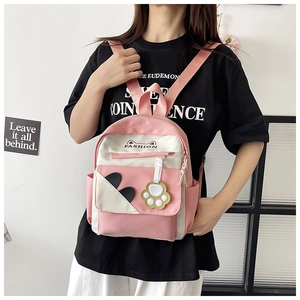 Detail of pink and white nylon mini backpack with cute cat ears and yellow paw charm
