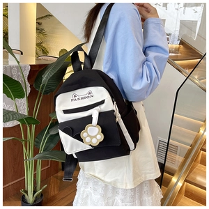 Detail of cute cat-ear canvas backpack with fashion print and paw pendant detail