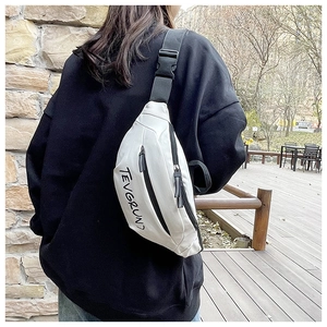 Close-up of white canvas crossbody bag with black lettering and adjustable strap