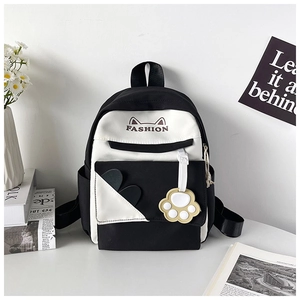 Close-up of black and white student backpack with cat ear embroidery and cute paw charm