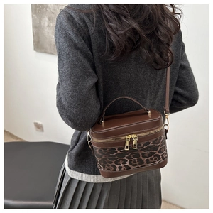Nahaufnahme der Leoparden-Beuteltasche mit braunem Patchwork und goldenen Reißverschlüssen