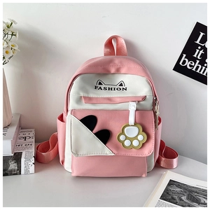 Detail of pink and white cat-ear backpack with fashion print and paw charm pendant
