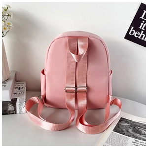 Detail view of pink mini backpack with adjustable fabric straps and side pockets