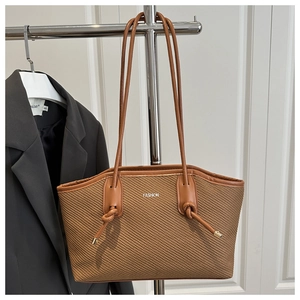 Détail d'un sac cabas tressé marron avec poignée en cuir et décoration de texte Fashion