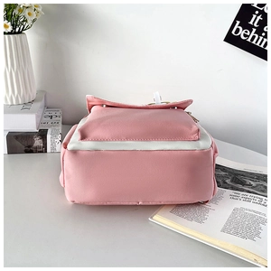 Detail of reinforced stitching and wide flat base on a pink and white nylon backpack