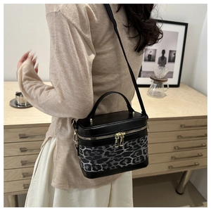 Détail latéral du sac seau léopard avec finitions en cuir et bandoulière réglable