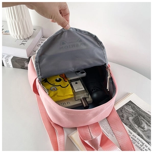 Detailed interior view of pink backpack showing spacious compartments for phone and umbrella