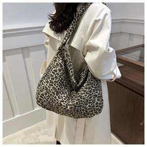 Detailed back view of a large leopard print canvas tote bag worn on shoulder