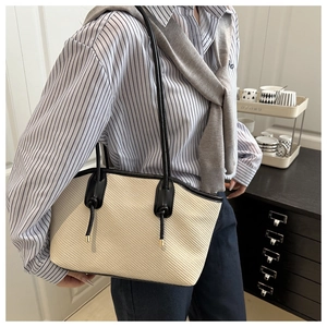 Détail de la texture tissée et de la bordure en cuir noir de ce sac fourre-tout