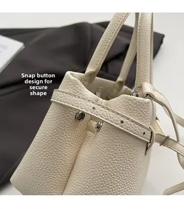 Detail of snap button design and fixed shape on beige lychee leather bucket bag