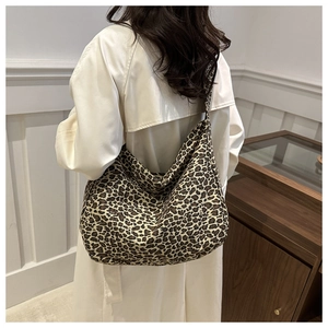Detail shot of oversized leopard print canvas tote bag styled with a minimalist beige coat