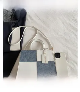 Top view of bicolor patchwork box bag with blue denim and white leather texture