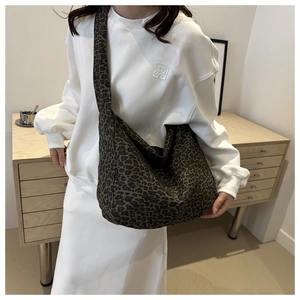 Detailaufnahme der großen Hobo-Tasche mit Leopardenmuster, getragen von einem Model