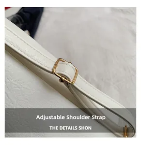 Detail of adjustable shoulder strap with gold buckle on white lychee leather tote bag