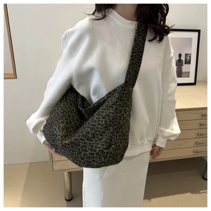 Detailed view of large leopard print canvas hobo bag showing the slouchy texture and wide strap