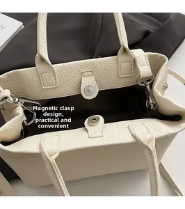 Detailed top view of off-white tote bag showing magnetic buckle and litchi grain texture